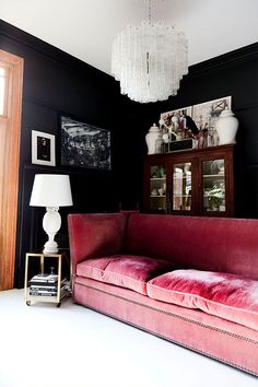 a living room with a pink couch and chandelier