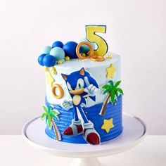 a sonic the hedgehog themed birthday cake on a white plate with blue and yellow decorations