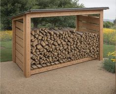 a large pile of logs sitting in the middle of a yard next to a wooden shed