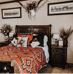 a bed room with a neatly made bed and two deer heads on the wall above it