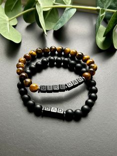 - Sleek and modern matte onyx and/or tiger eye gemstone bracelet personalized with initials, name word or whatever you please!  This beaded bracelet can be dressed up or dressed down for everyday wear. Beaded on high quality stretch cord and secured. Find other coordinating men's bracelets in shop. ** Lettering on beads is very subtle black on black**  - 8mm matte black onyx beads   8mm tiger eye beads   6mm matte black acrylic letter beads   hematite spacer beads - Please enter wording, initials or name for bracelet in personalization box. Feel free to reach out with any questions - Each purchase is sent in a velvet drawstring jewelry bag, making the perfect gift for dad, fathers day gift, gift for husband, bracelet gift for son or just yourself. - To care for your bracelet, please roll o Personalized Name Bracelet For Father's Day, Handmade Black Bracelets For Father's Day, Customizable Name Bracelet For Father's Day, Customizable Black Name Bracelet For Father's Day, Father’s Day Beaded Bracelet, Daddy Bracelet, Dad Bracelet, New Dad Gift, Men's Bracelets