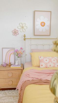 a bedroom with pink and yellow decor on the walls, bedding and nightstands