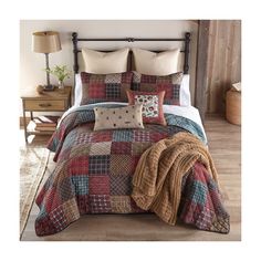 a bed with a plaid comforter and pillows