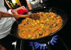 a person cooking food in a skillet on the stove