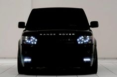 the front end of a black car with its lights on and text that reads luxury transportation arrangements