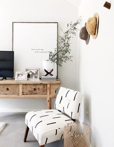 a room with a desk, chair and hat rack