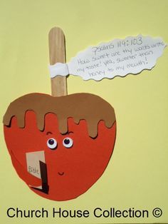 an apple with a stick sticking out of it's side and a note attached to it