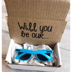 a cardboard box with sunglasses in it and the words will you be our? written on them