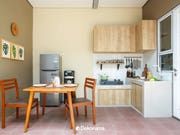 a kitchen with a table and chairs next to a refrigerator freezer in the corner