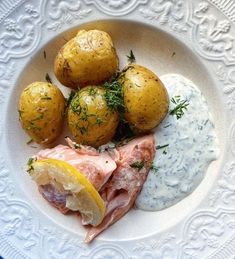 a white plate topped with potatoes and meat