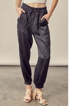 These edgy drawstring satin trousers are so edgy. We call them our fancy joggers. This staple is versatility at its best. A pair of flats can dress it down while your strappy heels can take you out for the night. Featuring a wide elastic waistband with a draw tie waist, the pockets and elastic ankle hem are the perfect compliment. Color: Black Wide Elastic Waist Fit: True to Size Pockets Elastic Ankle Hem 100% Polyester Follow Care Instructions Non-stretch Edgy Cotton Pants, Edgy Mid-rise Cotton Pants, Chic Non-stretch Pants With Frayed Hem, Black Ankle-length Harem Pants With Elastic Waistband, Black Ankle-length Joggers With Elastic Waistband, Satin Joggers, Satin Trousers, Pants Large, Classic Chic