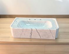 a marble sink sitting on top of a wooden counter