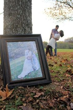 an old photo is placed in the grass next to a tree with leaves on it