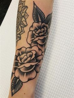 a black and white rose tattoo on the arm