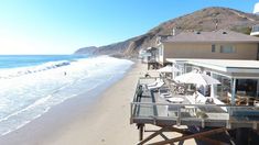 the beach is lined with chairs and umbrellas