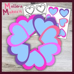 hearts cut out from paper on top of a wooden table with the words maker's makes it