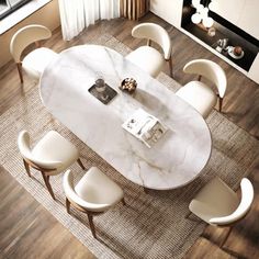 an aerial view of a dining room table with white chairs and a marble topped centerpiece