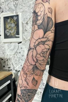 a woman's arm with flowers and leaves tattooed on her left arm by lora martin