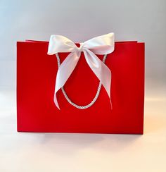 a red bag with a white bow on it