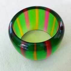 "Fabulous wide Lucite bracelet from the late 1960's early 1970's . Green in color with pink and yellow stripes. Dimensions: 2.5\" interior and 2.5\" wide. In excellent condition. Feel free to convo me with any further questions. Thank you for your interest." Handmade Retro Bangle Bracelet, Vintage Multicolor Bangle Bracelets, Retro Multicolor Bangle Jewelry, Retro Green Bangle Bracelets, Retro Multicolor Bracelets For Gift, Retro Multicolor Bracelets As Gift, Multicolor Retro Bracelets For Gift, Multicolor Retro Bracelet For Gift, Multicolor Retro Bracelet As Gift