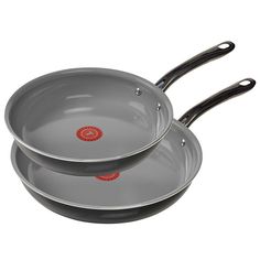 two pans with black handles are stacked on top of each other in front of a white background