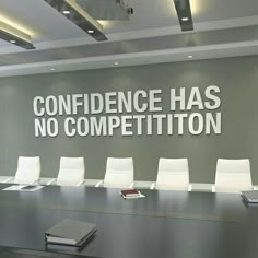 a conference room with white chairs and a large sign on the wall that says,'confidence has no competition '