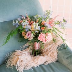 a bouquet of flowers sitting on top of a blue chair