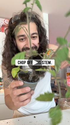 a man holding a potted plant with the words chop off on it in front of him