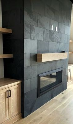 an empty room with a fireplace and shelves on the wall in front of it,