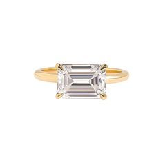 a yellow gold ring with an emerald cut diamond