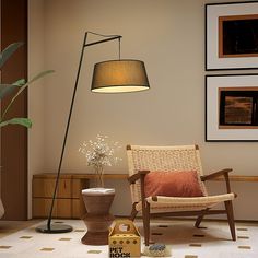 a living room with a chair, lamp and pictures on the wall