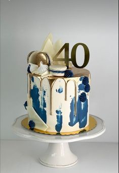 a white cake with blue and gold icing on it's top that says 40