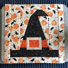 an orange and black patchwork quilt with a witch's hat on it