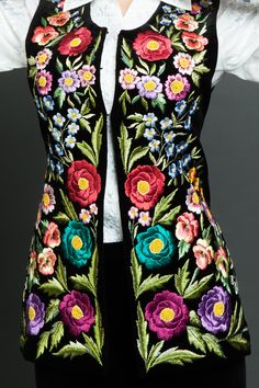 This velvet vest with hand embroidery has a fitted silhouette that beautifully emphasizes the figure of the owner. The black vest is made from velvet and has silk lining. Clasp of the formal vest consists of three hooks. The main decoration of this waistcoat is hand embroidery made by satin silk thread. As this long vest be made for order, please provide your body measurements - bust, waist, hips, length of the sleeve, length of the item and your height. Policies https://www.etsy.com/shop/Handem Embroidered Sleeveless Vest For Fall, Sleeveless Embroidered Vest For Fall, Black Floral Embroidery Sleeveless Vest, Elegant Embroidered Sleeveless Vest, Black Sleeveless Festival Vest, Bohemian Black Embroidered Vest, Bohemian Sleeveless Vest With Floral Embroidery, Sleeveless Bohemian Vest With Floral Embroidery, Fitted Multicolor Embroidered Vest For Festival