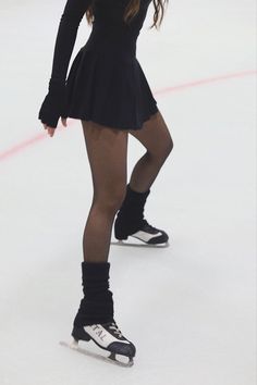 a female figure skating on an ice rink wearing short skirt and knee high socks with black tights