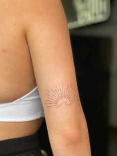 a woman's arm with a tattoo on it that has the sun shining down