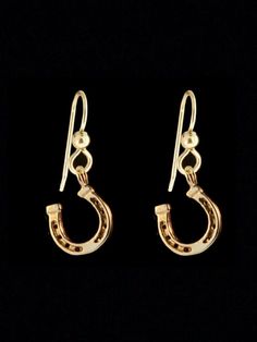 two pairs of gold earrings on a black background