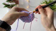 someone is crocheting a small ball of yarn with a crochet hook