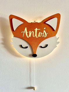 a wooden clock with the words antos on it's face and a fox head