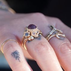 A garden snake wraps around a skull resting in a bed of flowers in an allegory come to life that you can wear on your finger. Named Nozarashi, Japanese for "weather beaten bones" in a twist on traditional memento mori rings. A snake for shedding old ways, flowers for growth, and an open minded skull to live life to the fullest. One of a kind and handmade in solid 14k yellow gold by Nick Potash in his Maui, Hawaii Studio. Carved 1.86ct pink tourmaline brain (there is a small imperfection in the back, but aren't all brains a little imperfect?), blue sapphire flowers, salt & pepper diamond skull eyes and a single orange sapphire snake eye. Size 4.5 and not resizable. Each Nozarashi Skull ring comes in a traditional Japanese Paulownia wood box designed to protect heirlooms from the environment Gemstone Skull Ring Gift, Unique Handmade Skull Ring, Handmade Luxury Vintage Skull Ring, Luxury Skull Ring With Gemstone, Skull Eyes, Garden Snake, Memento Mori Ring, Bed Of Flowers, Diamond Skull