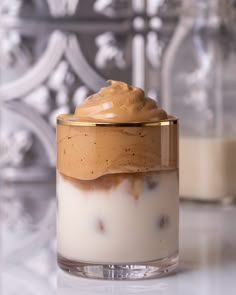 a dessert in a glass container with whipped cream and chocolate toppings on the top