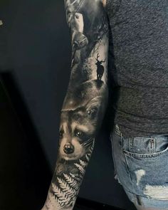 a man's arm with an animal and wolf tattoo on the left arm, while another person is standing in front of him