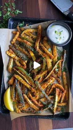 baked french fries with lemon wedges and ranch dressing on the side, ready to be eaten