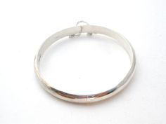 Fine Jewellery - This is a round high polished sterling silver bangle bracelet. It is hallmarked 925, signed FAS, slightly over .25" wide, inside diameter is 2.25", inside circumference is 7.25", and weighs 8.3 grams. It has sliding in locking clasp and safety chain. Any darkness or discoloration is only reflections. Classic Sterling Silver Bangle, Silver Bangle With Sterling Silver Clasp, Sterling Silver Bracelet With Shiny Finish, Silver Round Bracelet With Shiny Finish, Adjustable Bangle With Sterling Silver Clasp, Classic Sterling Silver Bracelet With Shiny Finish, Classic Round Bangle Stamped 925, Classic Silver Round Band Bracelet, Classic Silver Bracelet