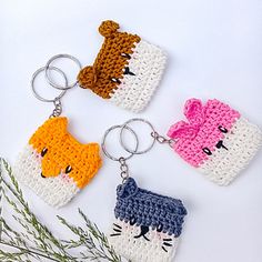 three crocheted keychains with cats on them, one has a cat and the other is a dog