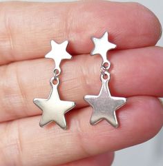 Stainless steel star charm and star stud earrings. These earrings are made of stainless steel only. Earring length: 26mm Charm material: stainless steel Earring stud material: stainless steel Backs: rubber This listing is for 1 pair of stainless steel star charm earrings. These earrings will come in an organza gift bag. I offer combined shipping costs which give you a shipping discount for ordering multiple items from my shop. Please note: this item will be sent for free via standard unregistere Silver Star Charm Earrings In Stainless Steel, Stainless Steel Star Charm Earrings For Gift, Star-shaped Stainless Steel Earrings For Gifts, Stainless Steel Star Charm Earrings Gift, Silver Stainless Steel Star Charm Earrings, Stainless Steel Star Earrings For Gifts, Star Shaped Stainless Steel Earrings For Gifts, Silver Stainless Steel Earrings With Star Charm, Hypoallergenic Star-shaped Metal Earrings