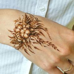 a woman's arm with hendix and flowers tattooed on her left hand