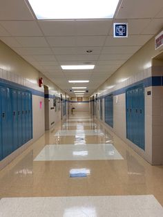 an empty hallway with blue and white lockers