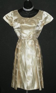 "In excellent condition, this dress has been stored away for 3/4 of a century or more, just to resurface here! It is gold satin brocade, custom made in Okinawa, Japan, as per the tag. It has a metal zipper, petite sizing. The bust will fit 34\", waist is 24\", hips free fitting to 50\", length is 43\", arm openings 12\" circumference, shoulders 15\", sleeves 5.5\"." Formal Gold Brocade Dress, Vintage Gold Dress For Evening, Vintage Gold Evening Dress, Vintage Gold Dresses For Evening, Formal Gold Silk Dress, Gold Silk Dress For Formal Occasions, Vintage Brocade Party Dress, Gold Silk Dress With Fitted Bodice, Vintage Fitted Dresses For Church