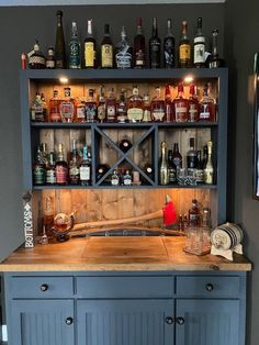 an old fashioned bar with lots of liquor bottles on the shelves and behind it is a baseball bat